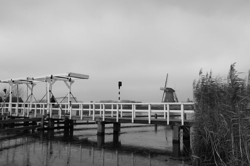 Free Scenic black and white photo of the iconic Kinderdijk windmill and bridge, Holland. Stock Photo