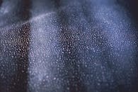 黑暗表面纹理上闪烁的散景灯特写，创造出抽象图案