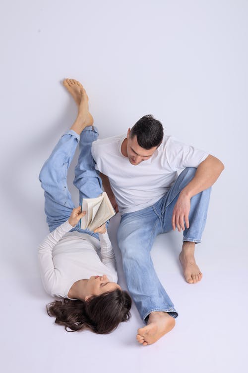 Woman Lying Down with Sitting Man in Jeans