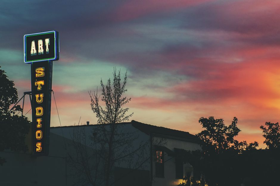Colorful neon art studio sign illuminated at twilight in Paso Robles, California.