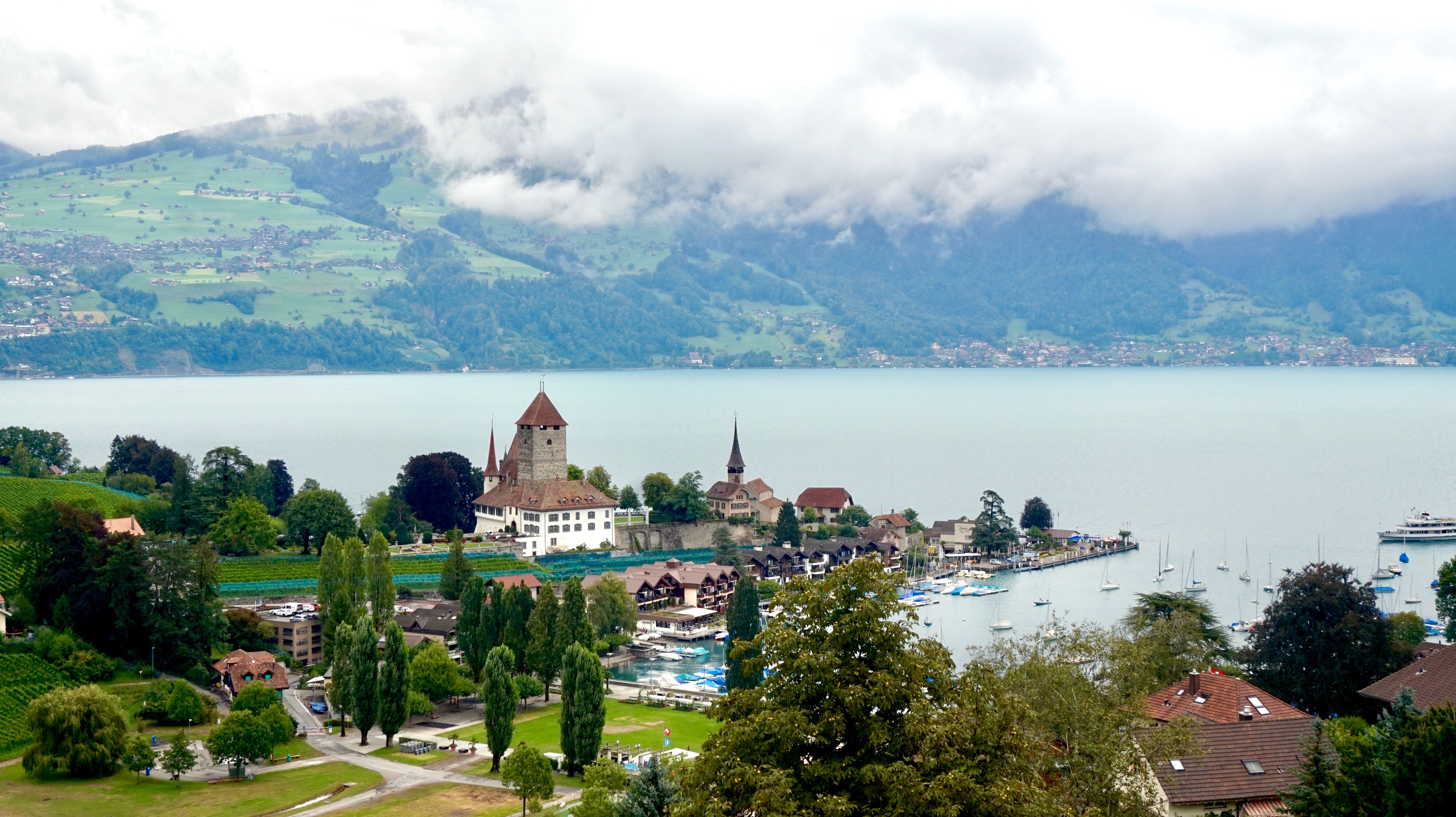 aerial view of white medieval village on hilltop overlooking vast lake