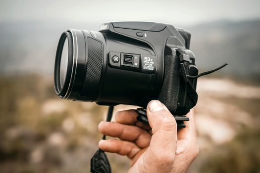 Close-up of a hand holding a camera outdoors in Collo, Algeria.