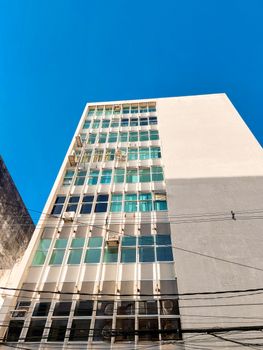 Low angle view of a modern office building in Recife, Brazil, against a clear blue sky.