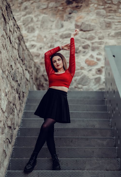 Foto profissional grátis de blusa vermelha, cropped, de pé
