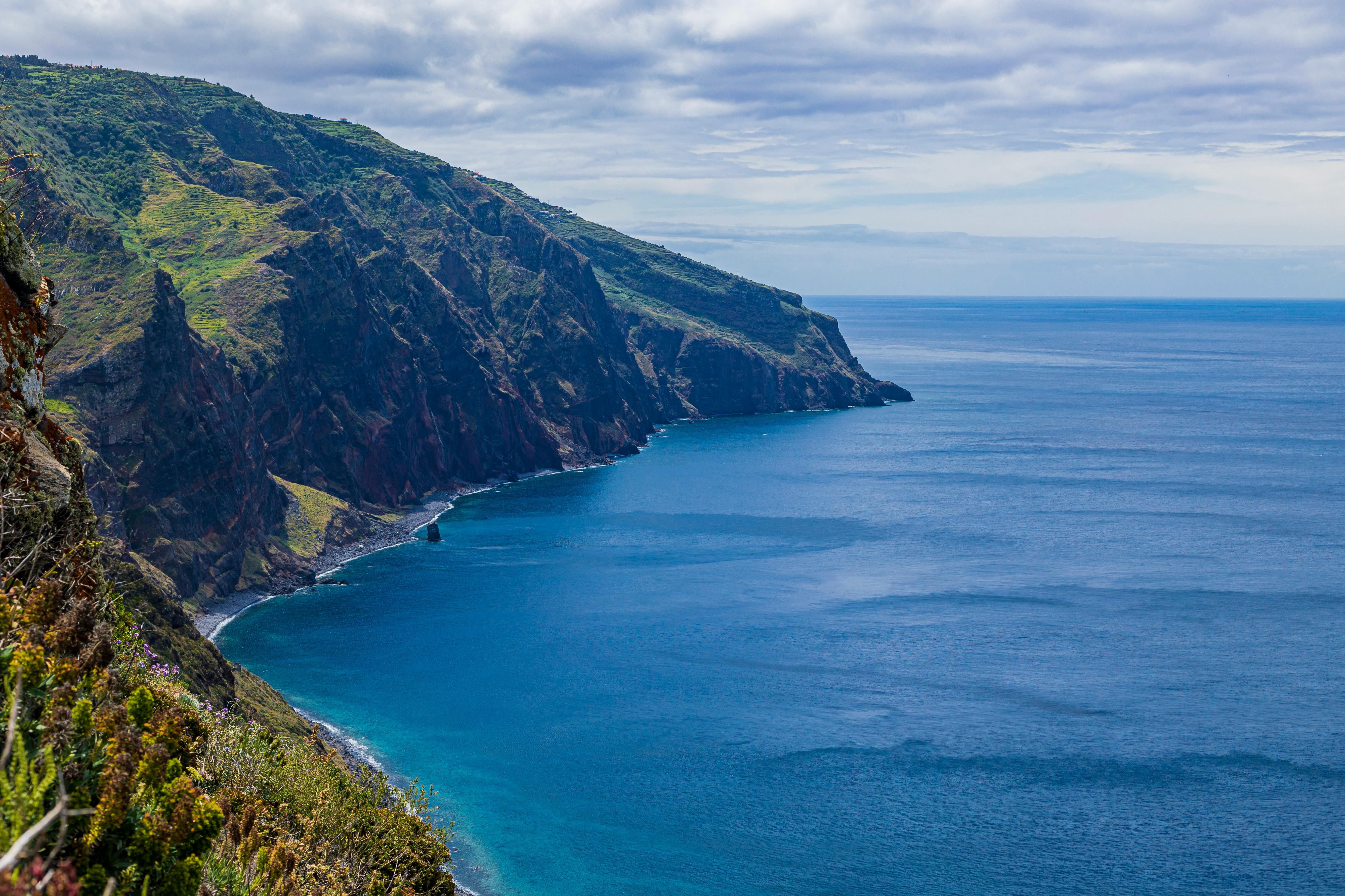 Breathtaking view of Madeira Island's rugged cliffs and blue ocean waters, a travel highlight.