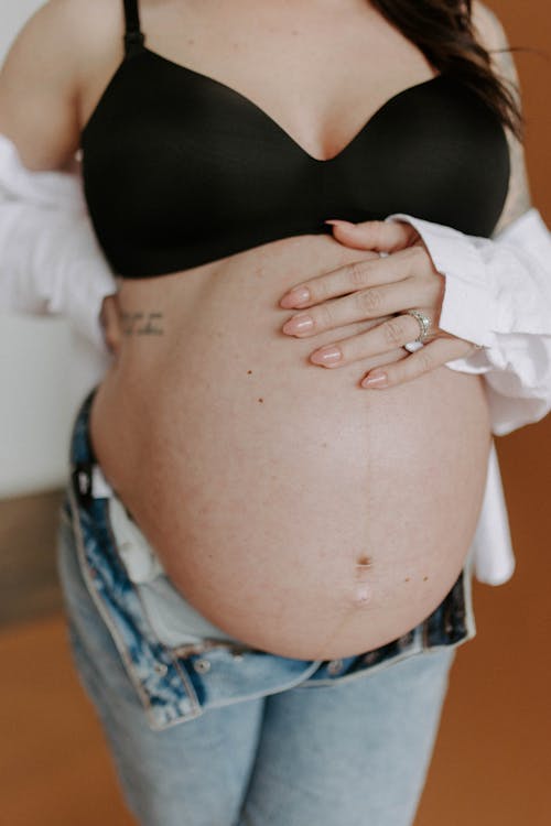 Gratis arkivbilde med BH, dongeribukser, gravid