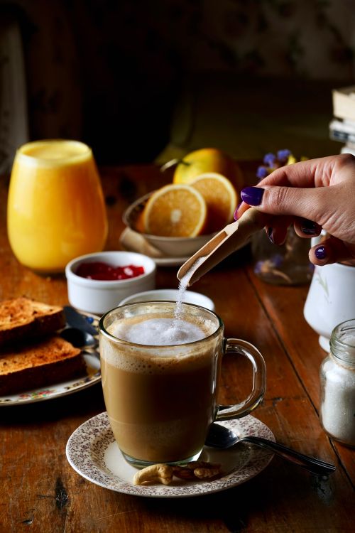 Free Inviting breakfast spread with cappuccino, orange juice, and toast on a rustic table. Stock Photo
