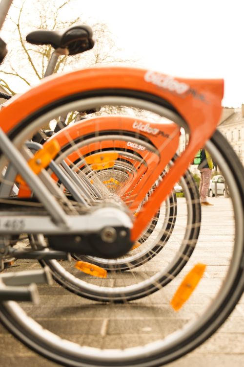 Free Colorful city bicycles parked in line in Nantes, France, depicting urban transportation. Stock Photo