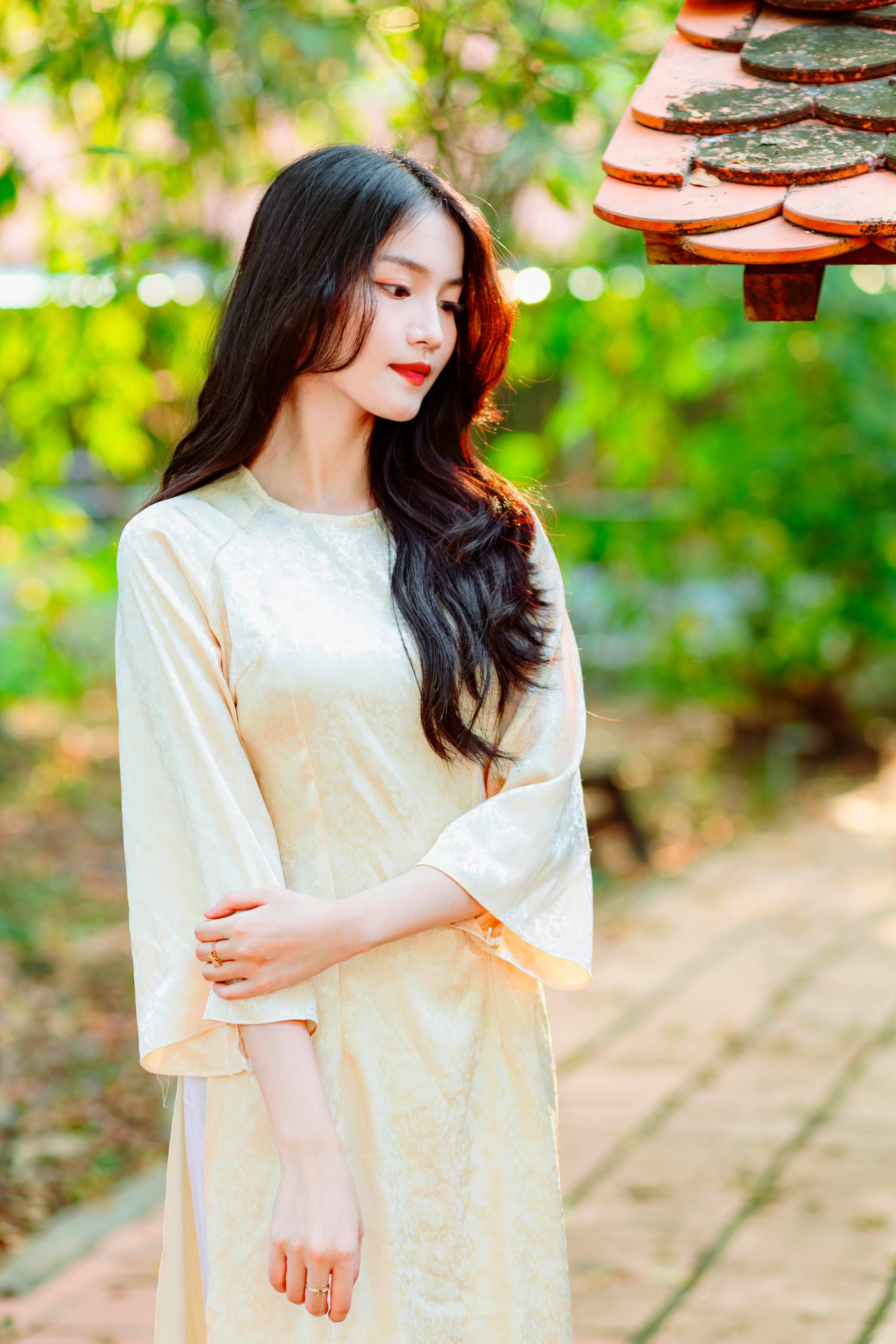 A serene portrait of a woman in a silk dress in a tranquil outdoor setting.