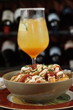 Delicious gourmet fries paired with a refreshing cocktail in a restaurant setting.