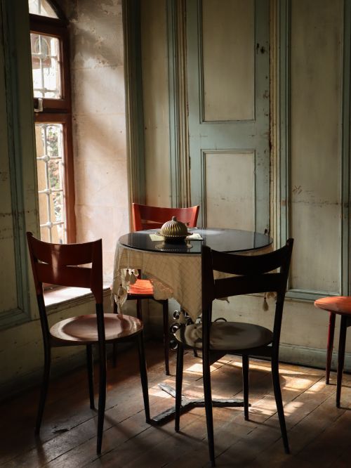 Free A serene, vintage-style dining area with classic wooden furniture and soft natural lighting. Stock Photo