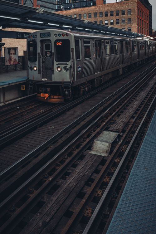 Free Passenger train arriving at a city railway station platform, showcasing urban transportation. Stock Photo