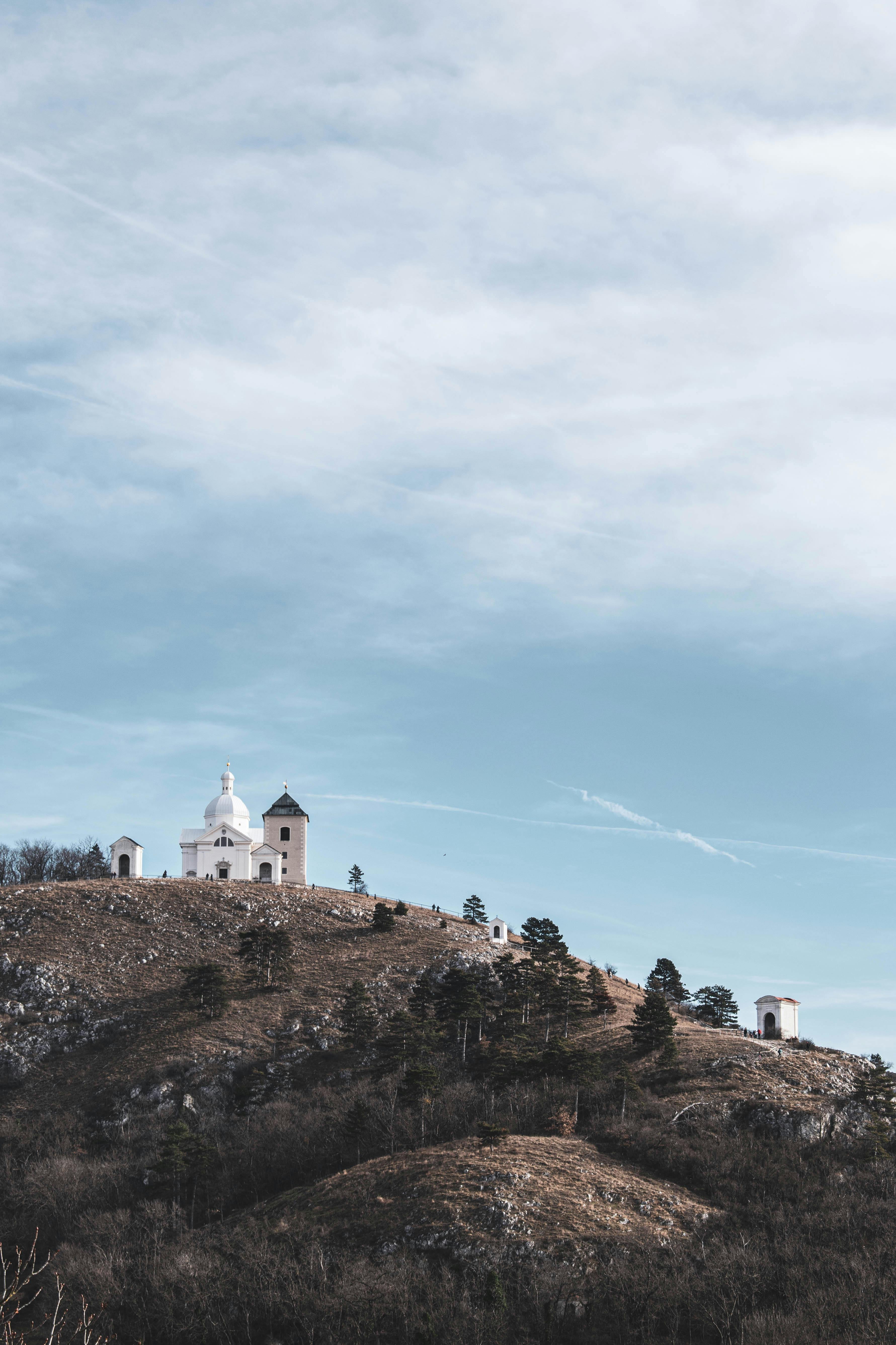 Serene landscape of St. Sebastian's Chapel on a hill under a vast sky.