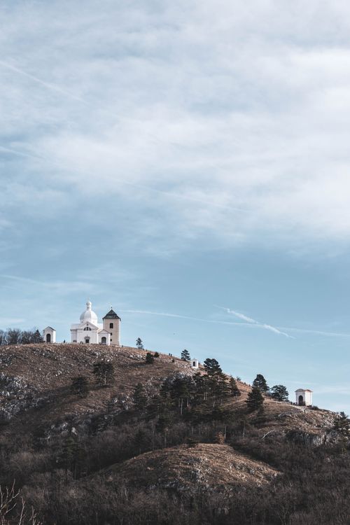Free Serene landscape of St. Sebastian's Chapel on a hill under a vast sky. Stock Photo
