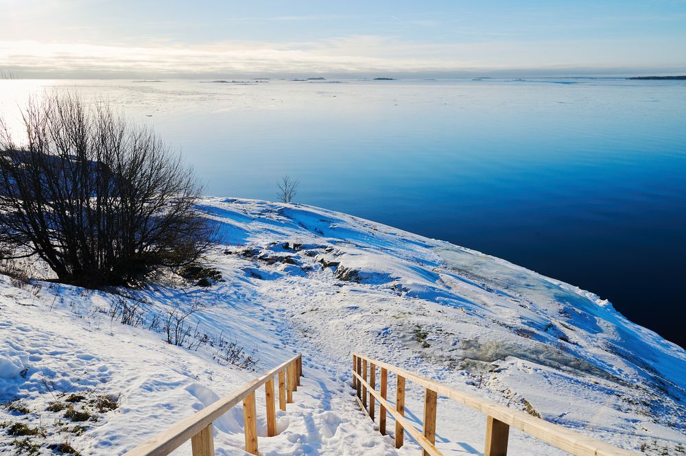Scări de lemn cu balustradă coborând în marea înghețată, la Helsinki, iarna
