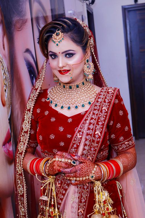 Free Traditional Indian bride in red saree with ornate jewelry indoors. Stock Photo