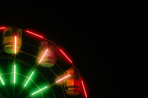 A ferris wheel with green and red lights