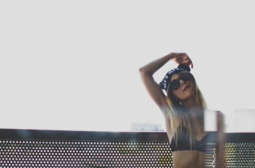 A woman in a bikini top and sunglasses