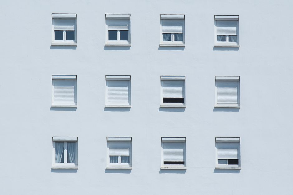 Symmetrical arrangement of windows on a white residential building facade in Lorient, France.