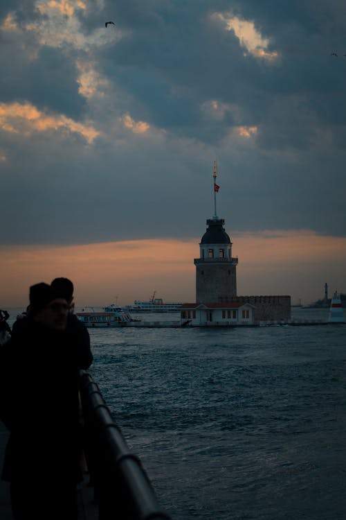 A couple standing on a pier looking at the water