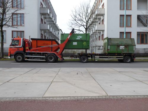 Free Orange garbage truck with green containers in urban Amsterdam, showcasing industrial city life. Stock Photo