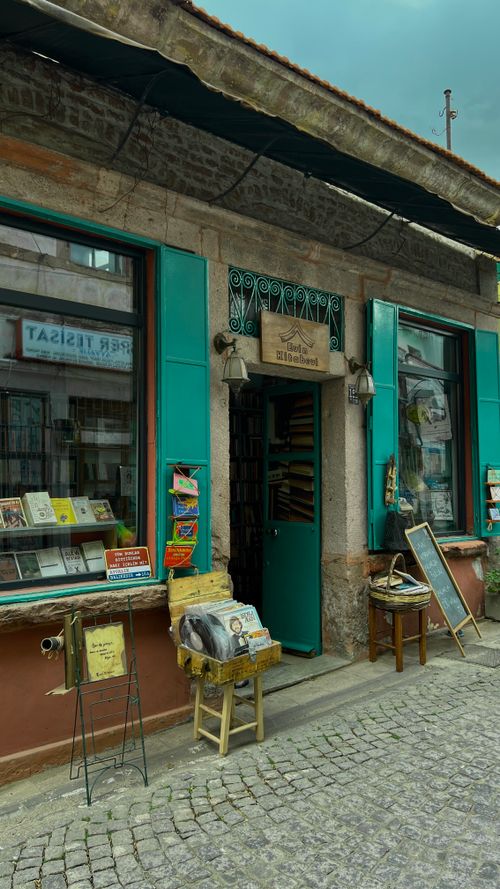 Free Vintage bookstore entrance with green accents on a cobblestone street. Quaint urban scene. Stock Photo