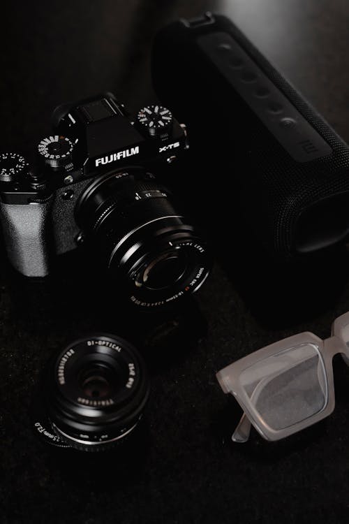 A camera, sunglasses and a pair of glasses on a table