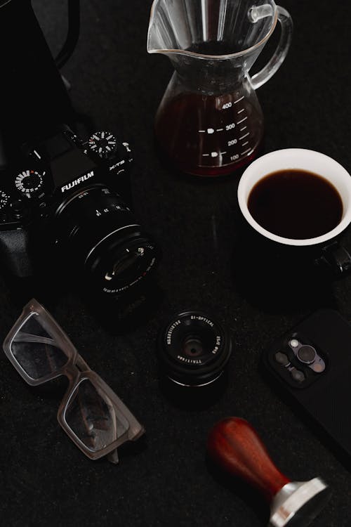 A coffee cup, a camera, and a pair of glasses