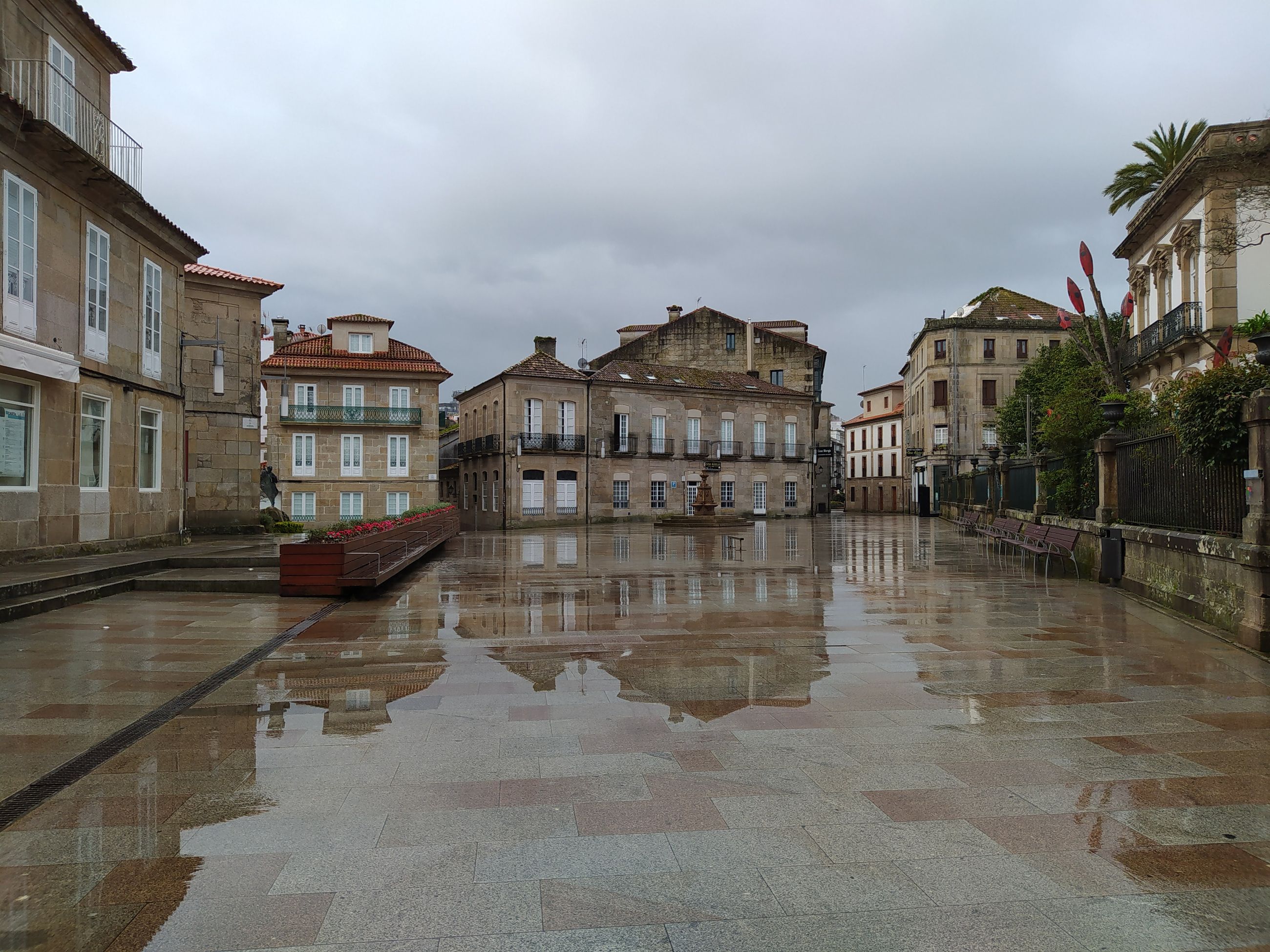 A wet European square reflecting old buildings on a rainy day. Photo by arturo martinez on Pexels