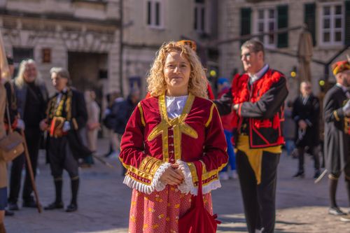 Free Woman in vibrant historical costume participates in an outdoor festival. Stock Photo