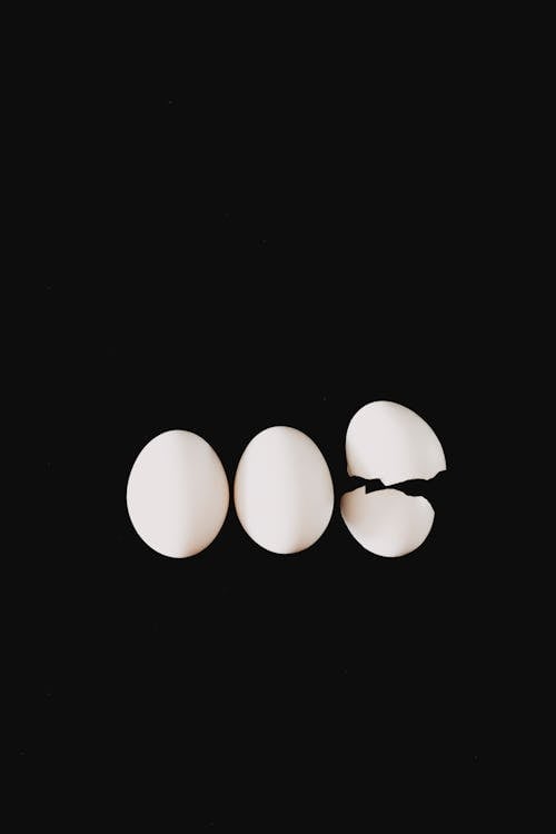 Three white eggs on a black background