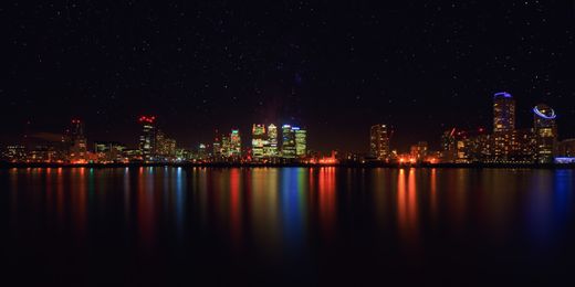 City skyline reflected on the harbour at night — photo by Johannes Plenio on Pexels