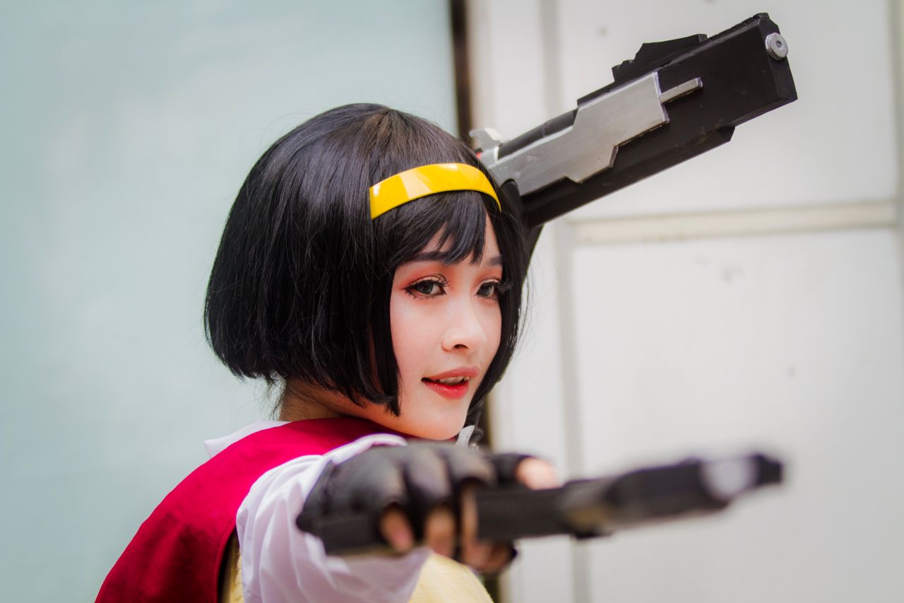 close up of a woman in cosplay attire aiming toy guns showcasing detai