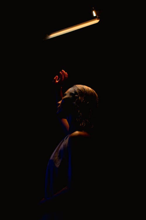 A woman holding a lit candle in the dark
