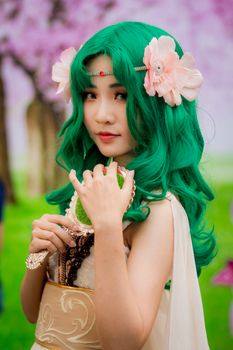 Captivating cosplay character with vivid green hair, embodying fantasy and creativity in a stunning costume.