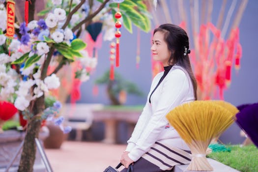 Woman among colorful decorations and incense in a traditional Asian festival setting.