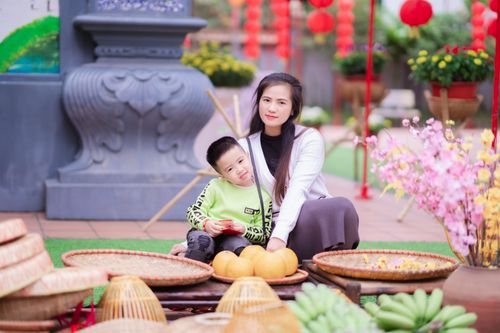 Free A mother and her son enjoy a vibrant outdoor festival with traditional decorations. Stock Photo