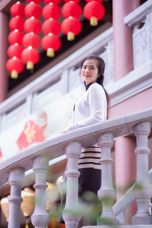 Smiling Woman Standing behind Railing