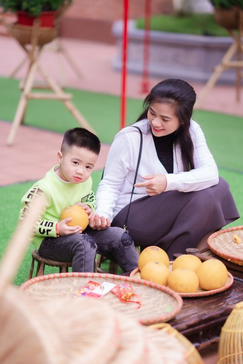 Free A smiling woman and boy enjoy outdoors with fresh grapefruits. Stock Photo