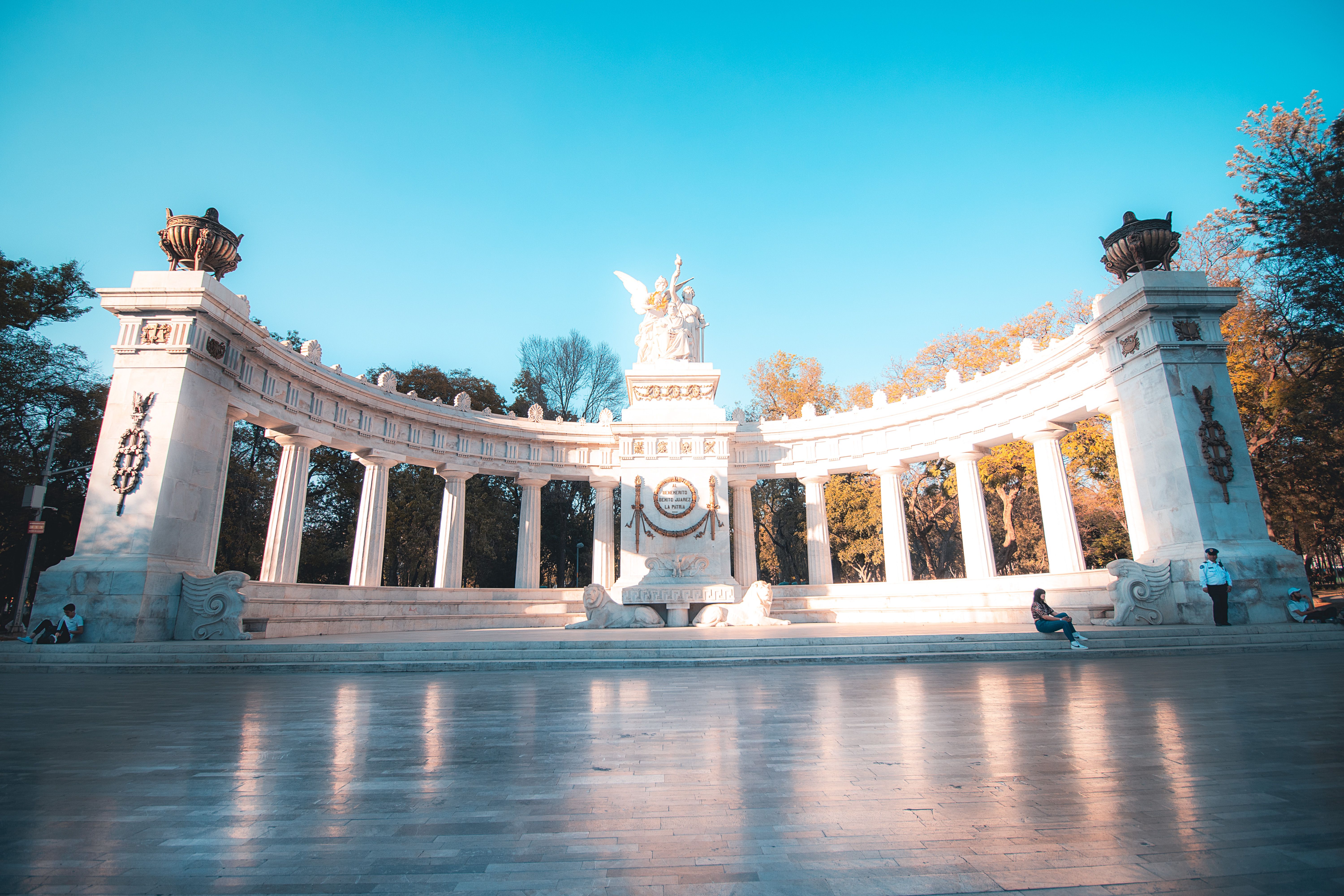 Sunlit Benito Juárez Hemicycle in Mexico City's Alameda Central park.