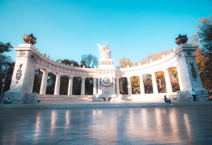 Sunlit Benito Juárez Hemicycle in Mexico City's Alameda Central park.