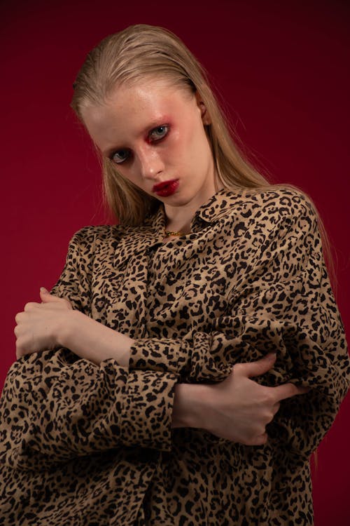 Blonde Posing in the Leopard Patterned Clothing, against a Dark Red Background