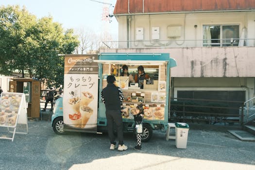 Urban street food scene with a crepe food truck serving customers in Toyota, Japan.