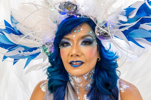 Free Striking portrait of a woman with a blue headdress and glitter makeup. Stock Photo