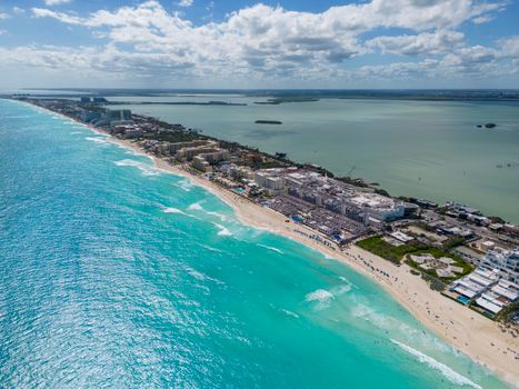 Aerial view of Cancun's pristine beaches and turquoise waters on a sunny day.
