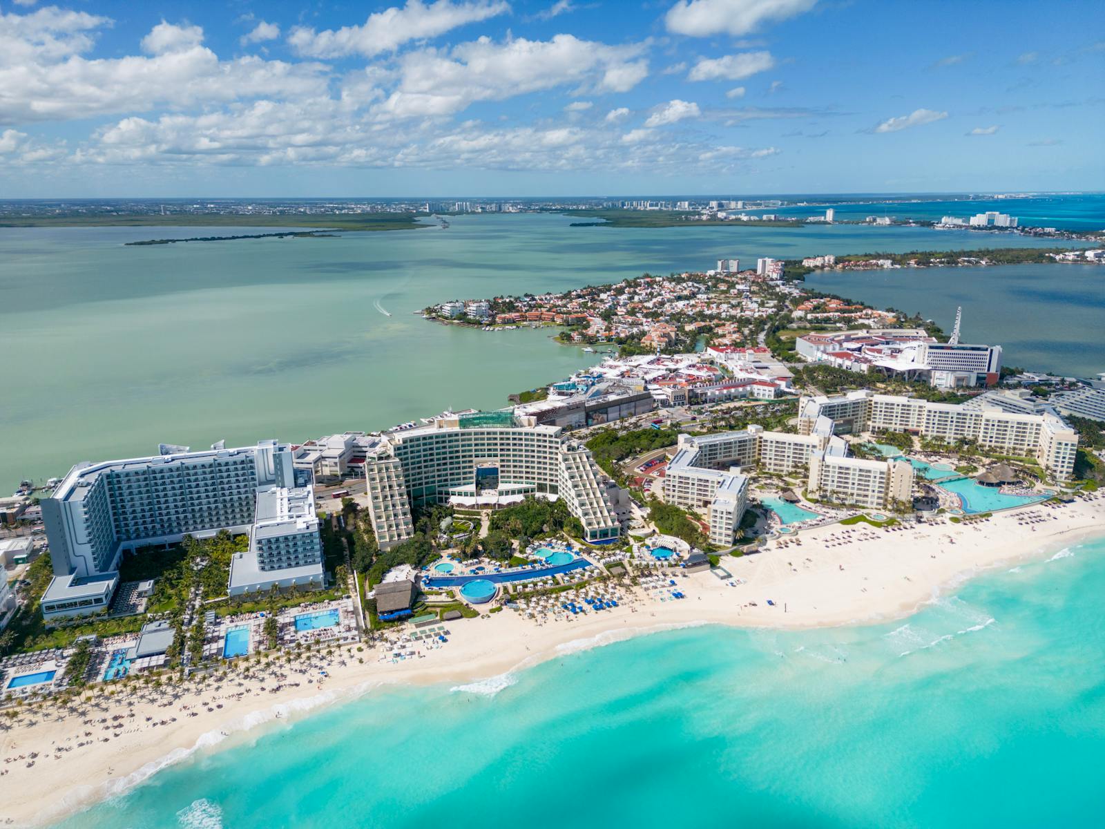 Vue aérienne des plages de Cancun avec des eaux turquoise et des resorts de luxe.