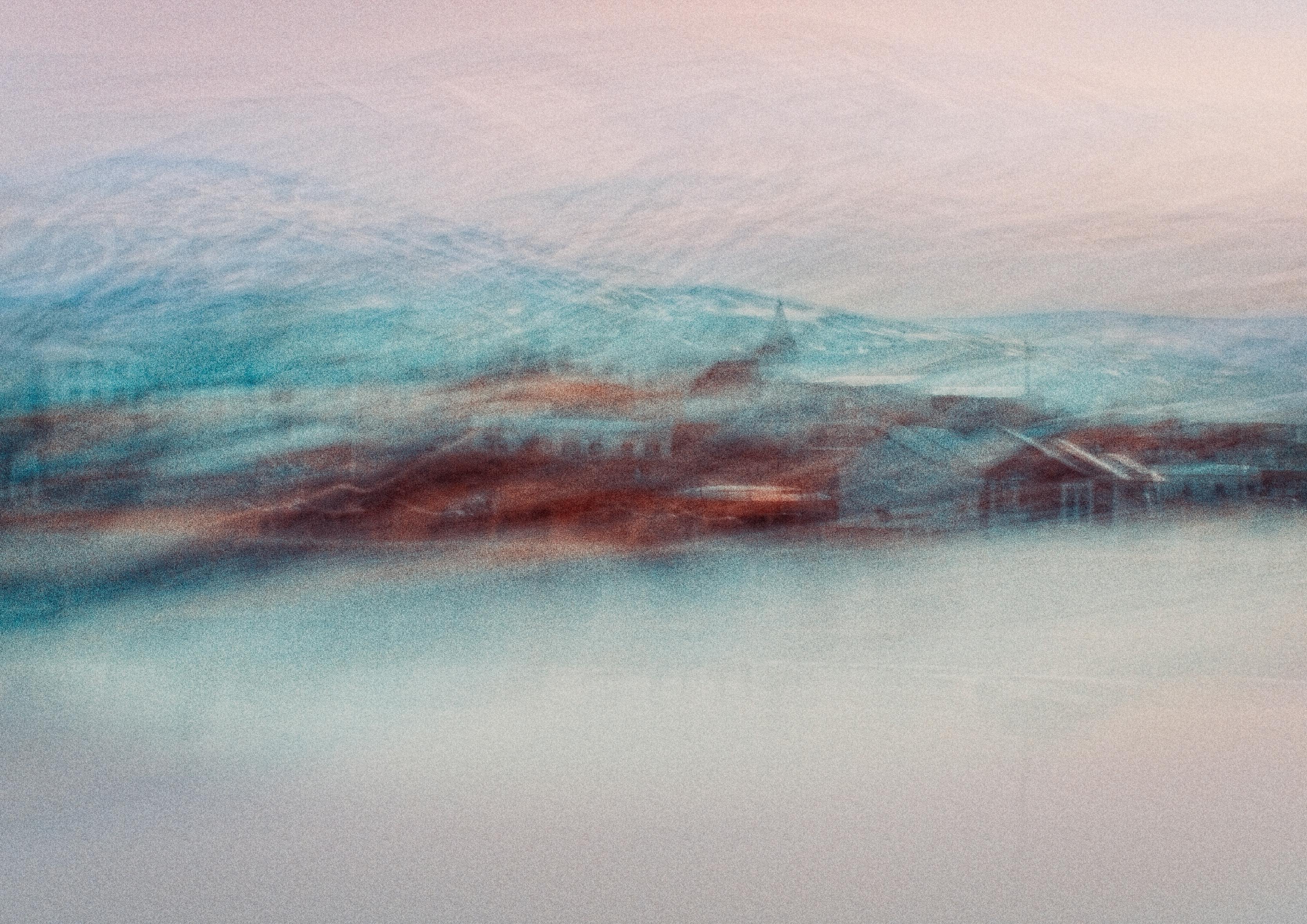 Blurred abstract image of a snowy village under a misty winter sky.