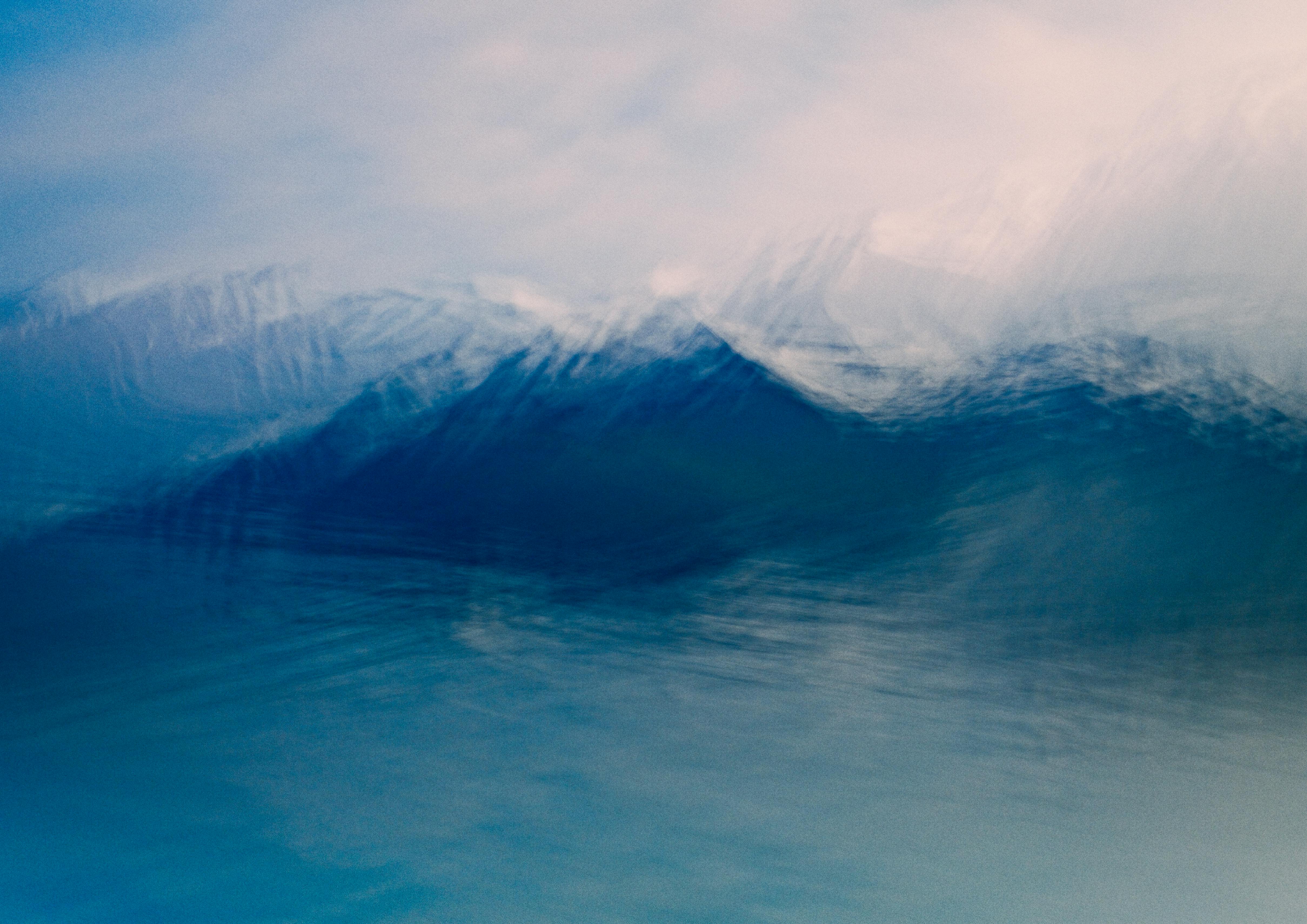 Blurred abstract image capturing the serene movement of ocean waves in shades of blue.
