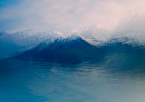 Blurred abstract image capturing the serene movement of ocean waves in shades of blue.