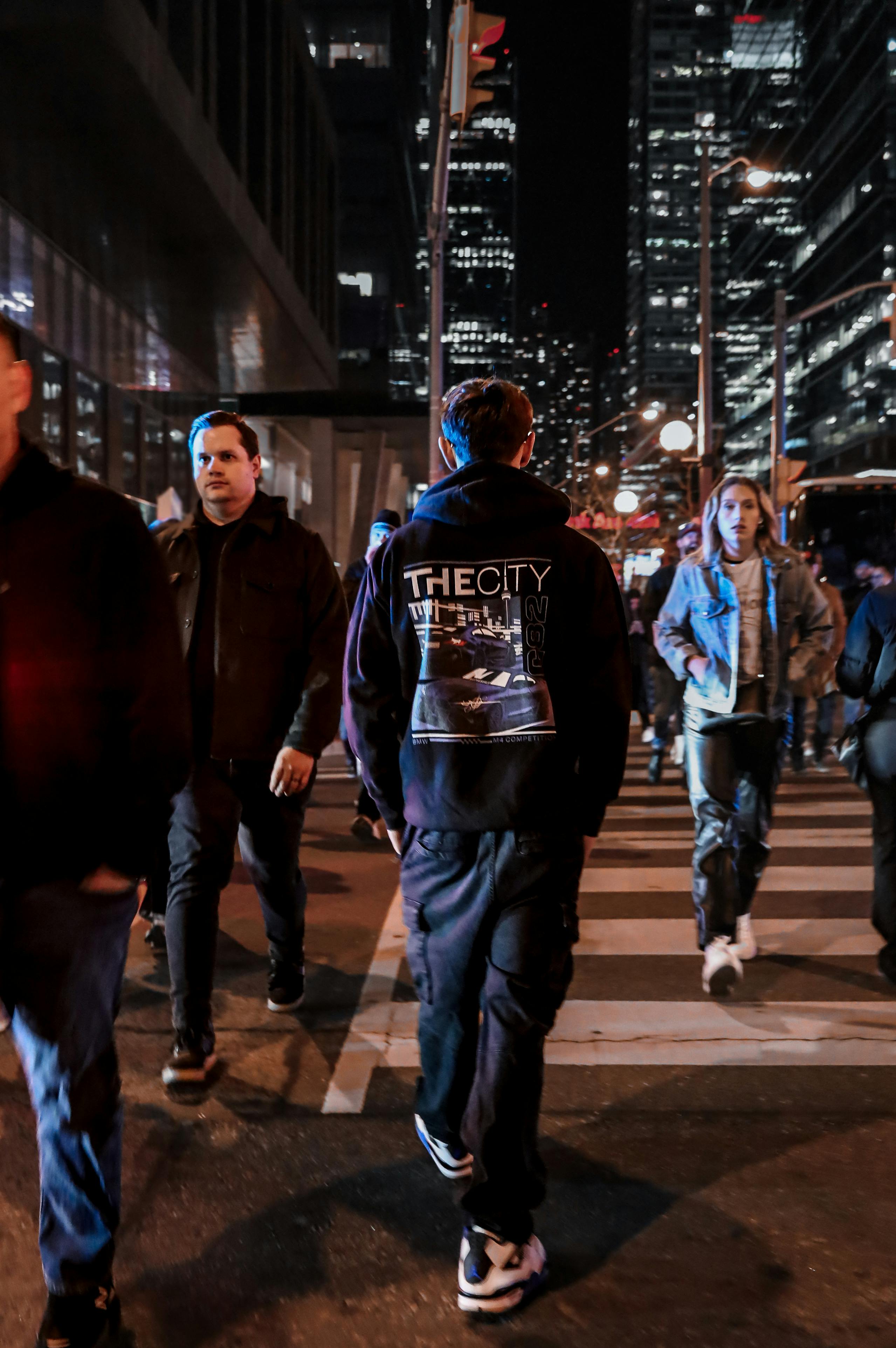 Pedestrians walking in a city at night under streetlights, representing the improved safety conditions for people on foot along Boulder Highway